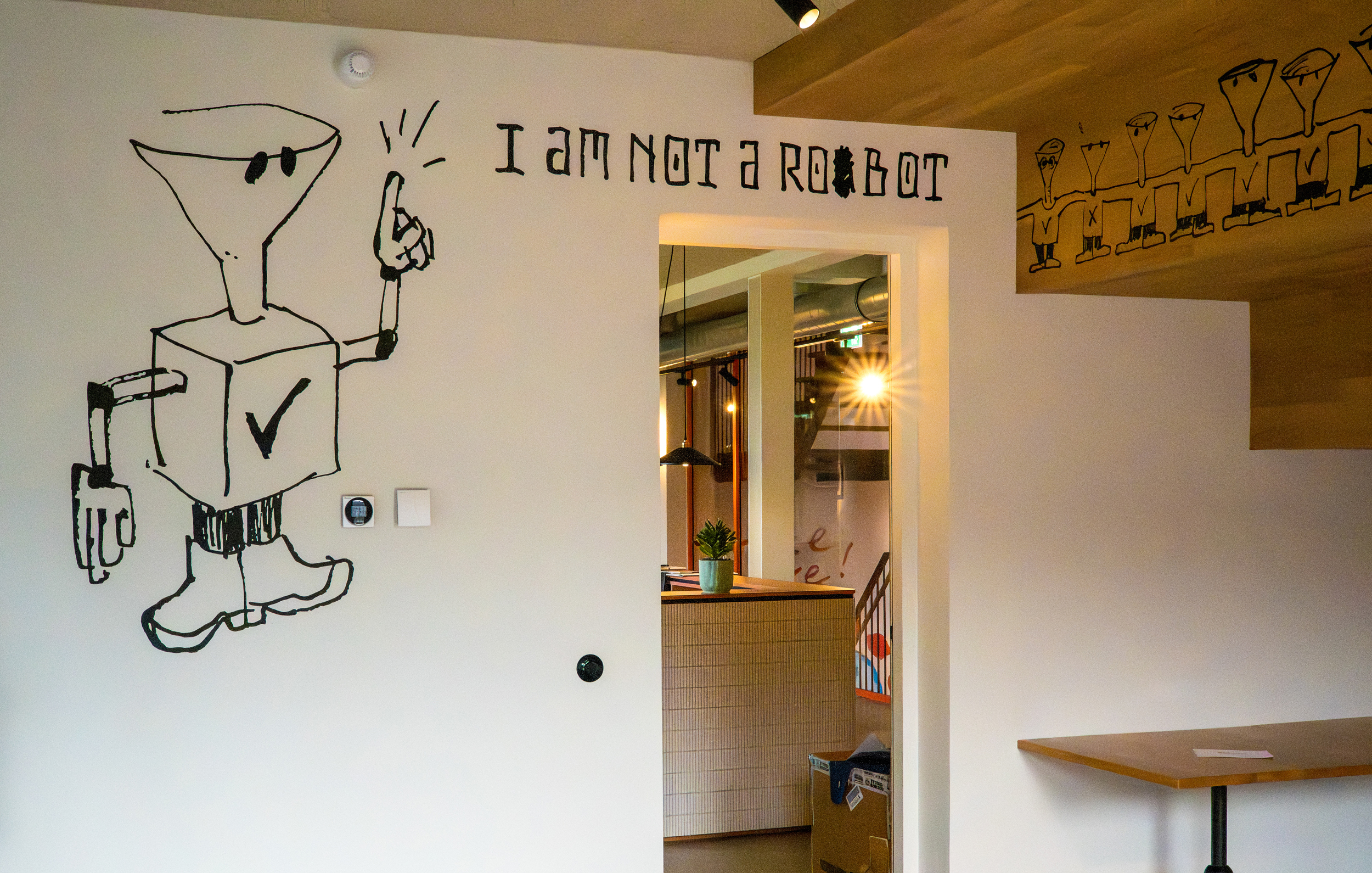 Muurtekening in het Dokhuis in Rotterdam: een robot met trechterhoofd en de tekst I am not a robot